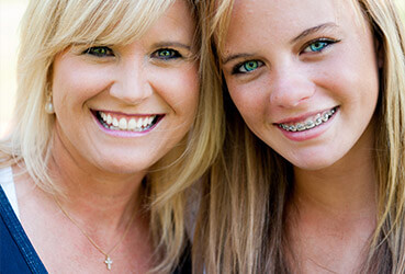 girl with traditional braces with her mother