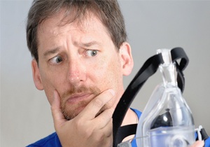 Man unsure of wearing CPAP device.
