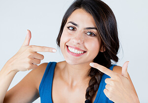 woman pointing to her straight teeth