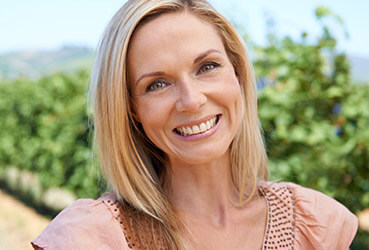 woman wearing pink top, smiling