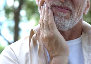 Distressed man in pain before seeing an emergency dentist in Herndon 