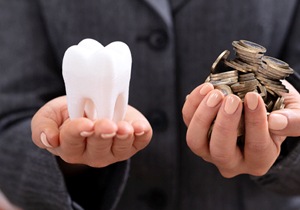 Someone holding a tooth in one hand and coins in the other