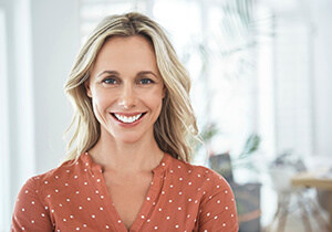 woman with white teeth, wearing a pink top