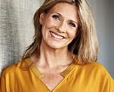 woman wearing yellow top, smiling